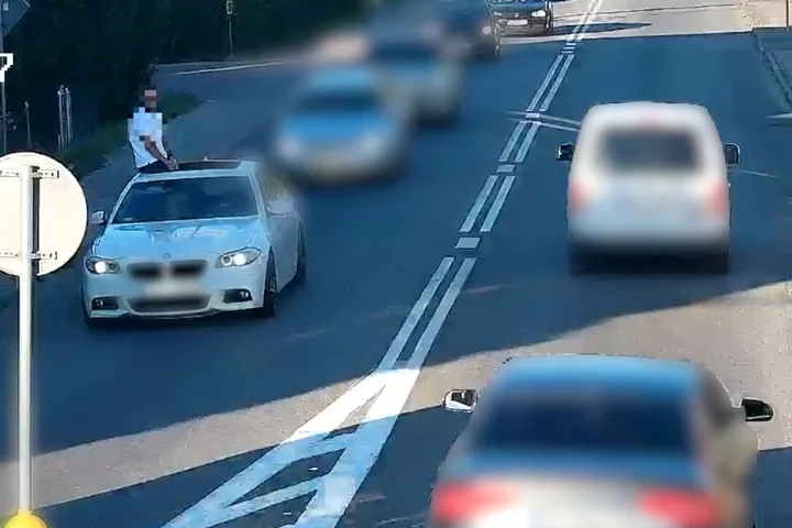 Pasażer siedział na dachu jadącego BMW. Kierowca stracił prawo jazdy